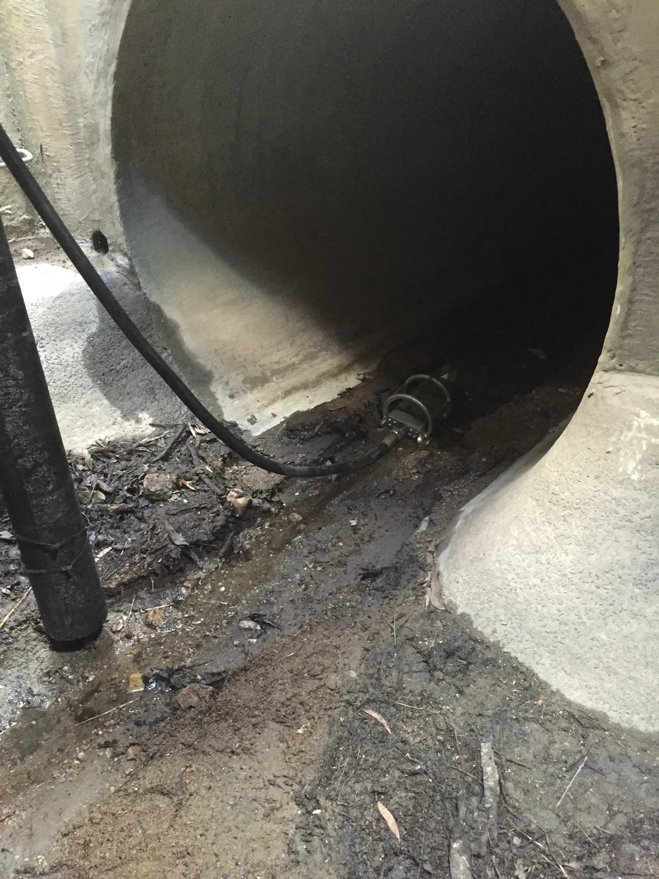 Vacuum and drain cleaning equipment working inside a large drainage pipe