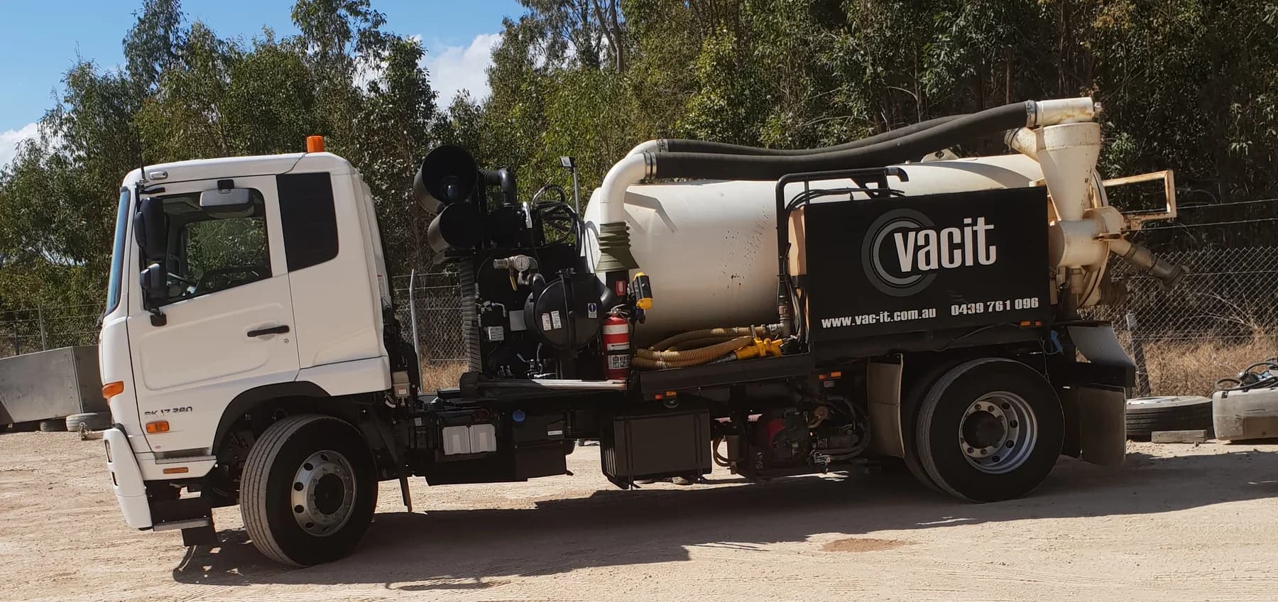 VACIT VAC 83 vacuum truck, tank and hose reel visible along the side