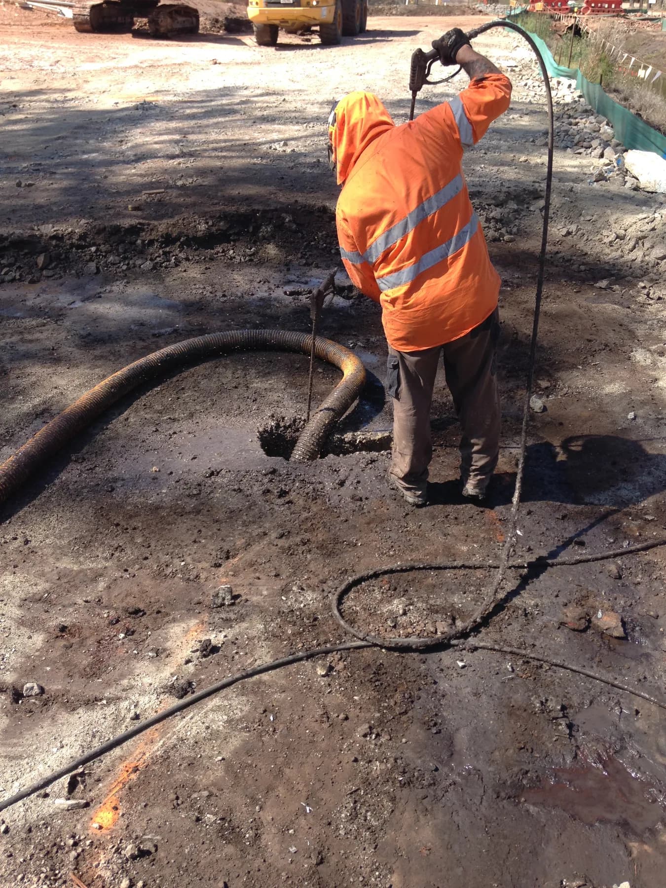 VACIT operator using controlled water during excavation work